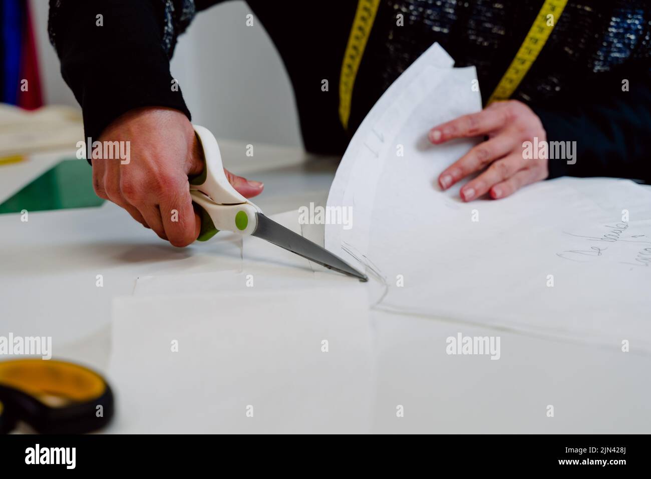 Dressmaker with scissors cutting cloth Stock Photo Alamy