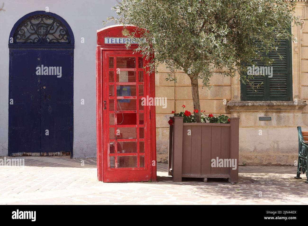 A British K6 telephone kiosk situated outside the police station in the market square at Nadur, Gozo. Stock Photo