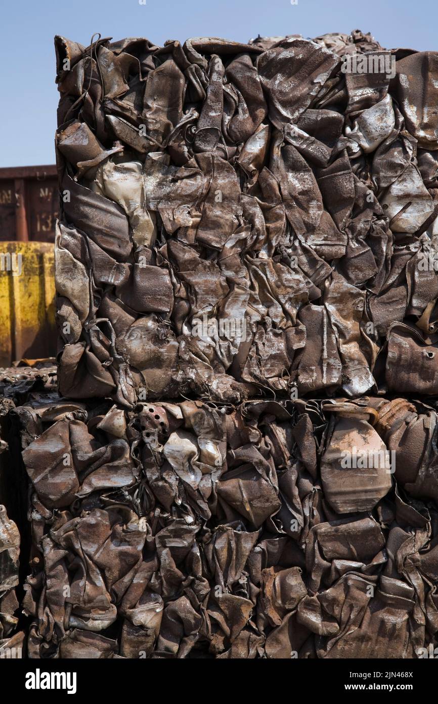 Bales of crushed and compacted gas tanks at scrap metal recycling yard. Stock Photo