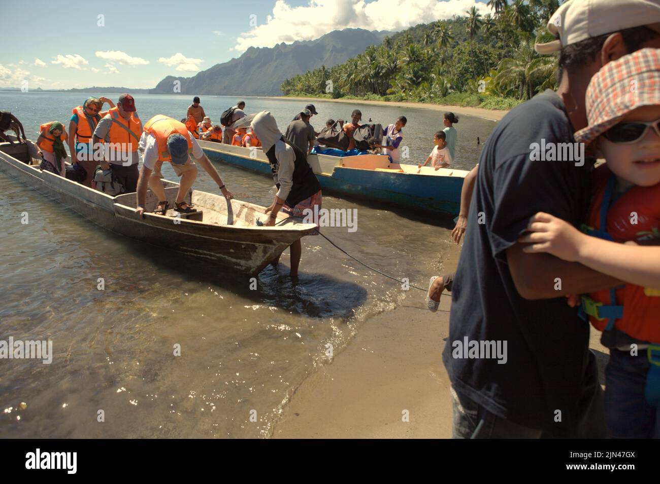 Villagers welcoming a boat carrying tourists on the beach of Horale village in Seram Utara Barat, Maluku Tengah, Maluku, Indonesia. Stock Photo