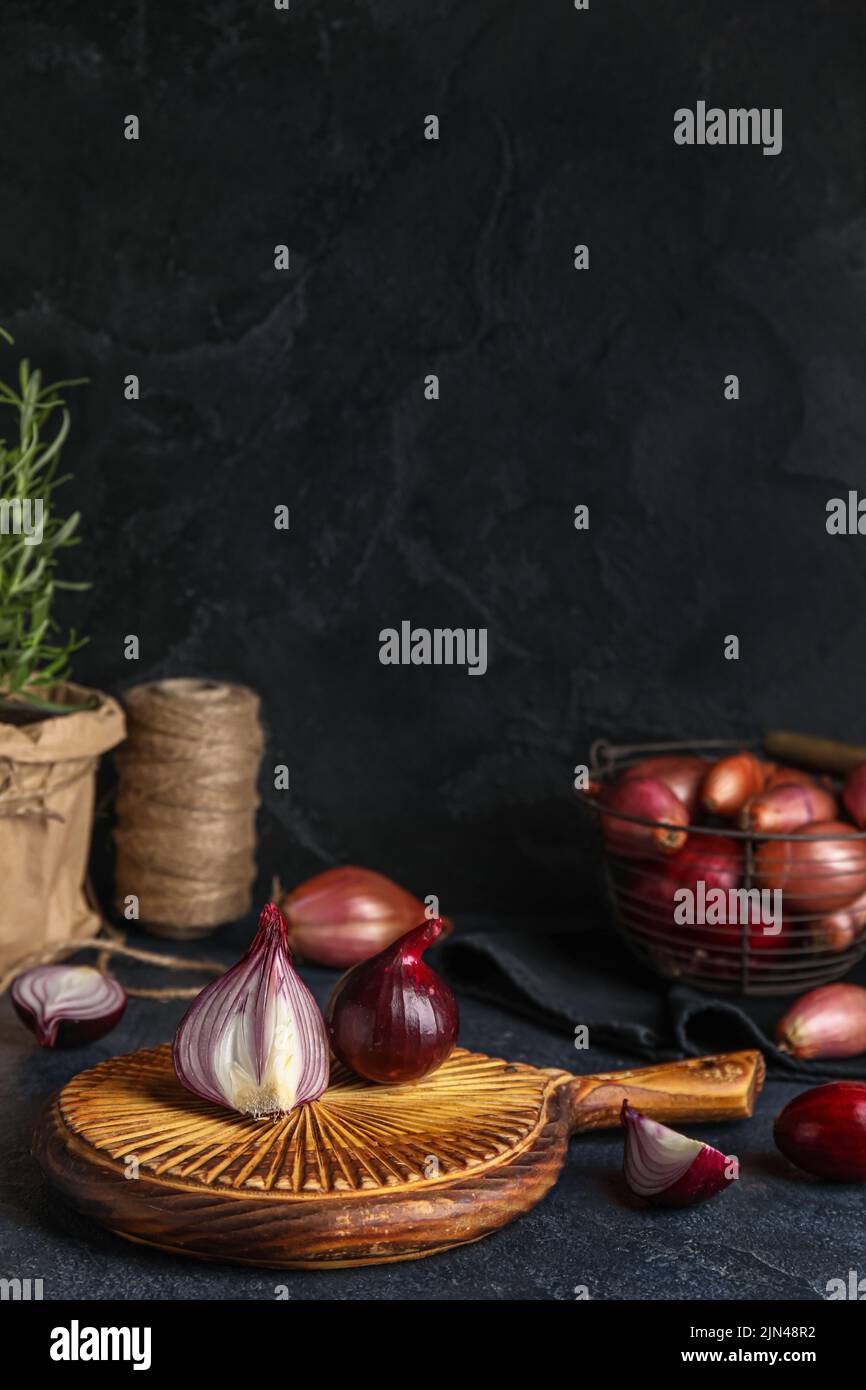 Wooden board with red onion on dark background Stock Photo - Alamy