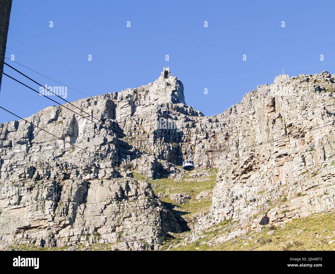Table Mountain with cable car rising to station at top of famous landmark. Stock Photo