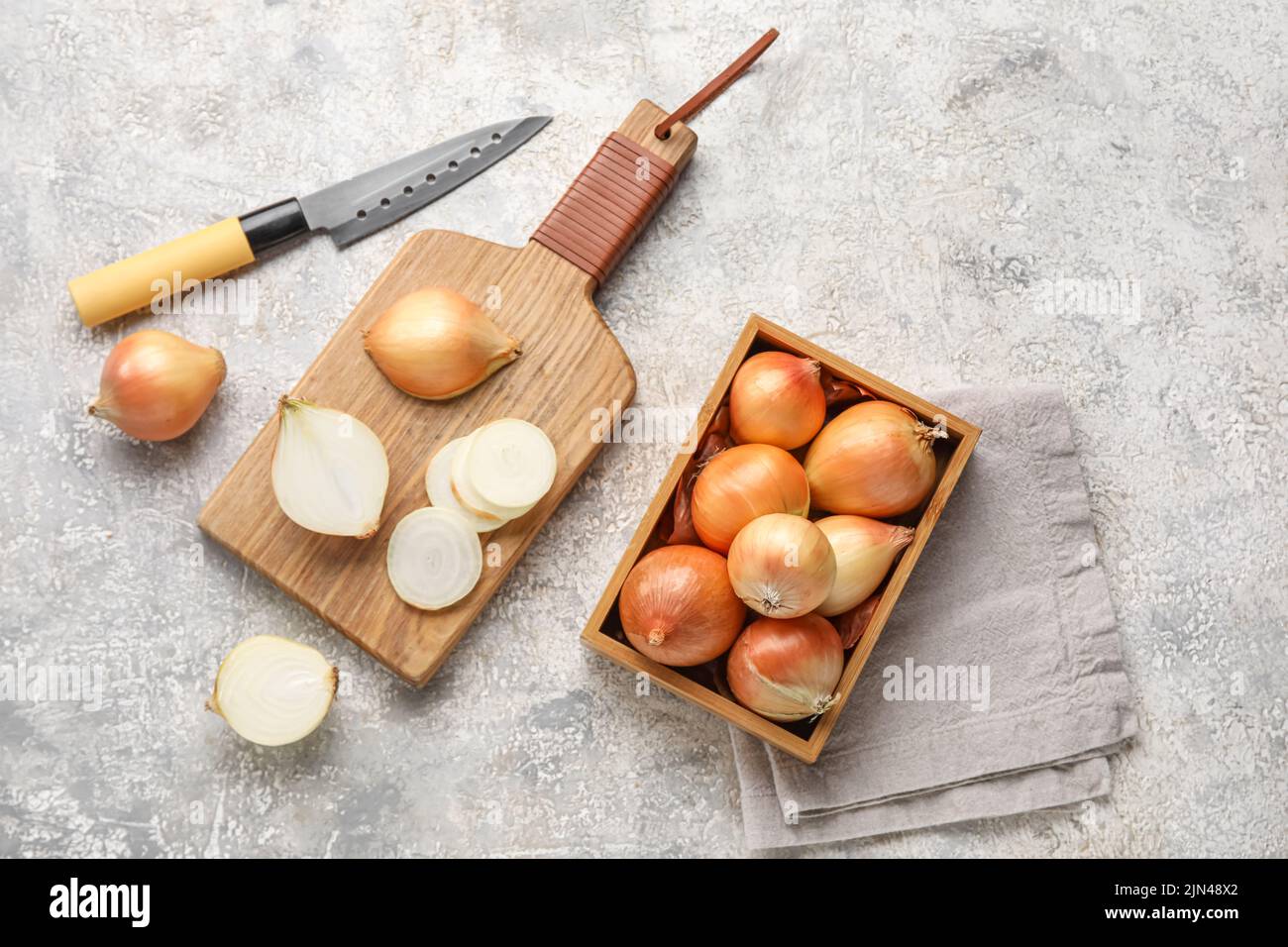 Composition with wooden board and box of onion on grunge background ...