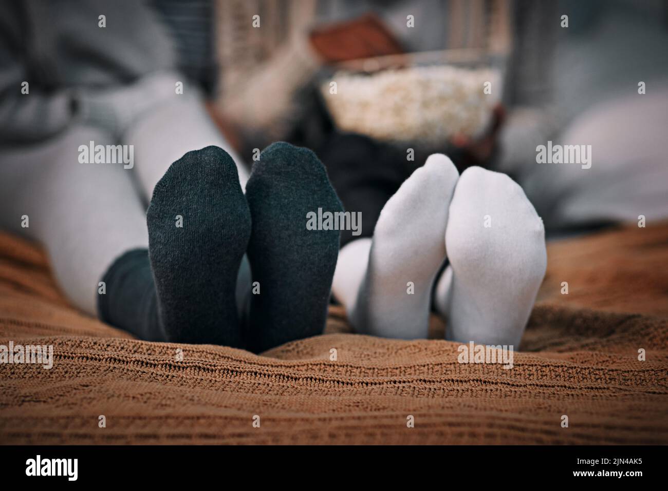 Warm and comfy. two young women wearing socks while lying on a bed