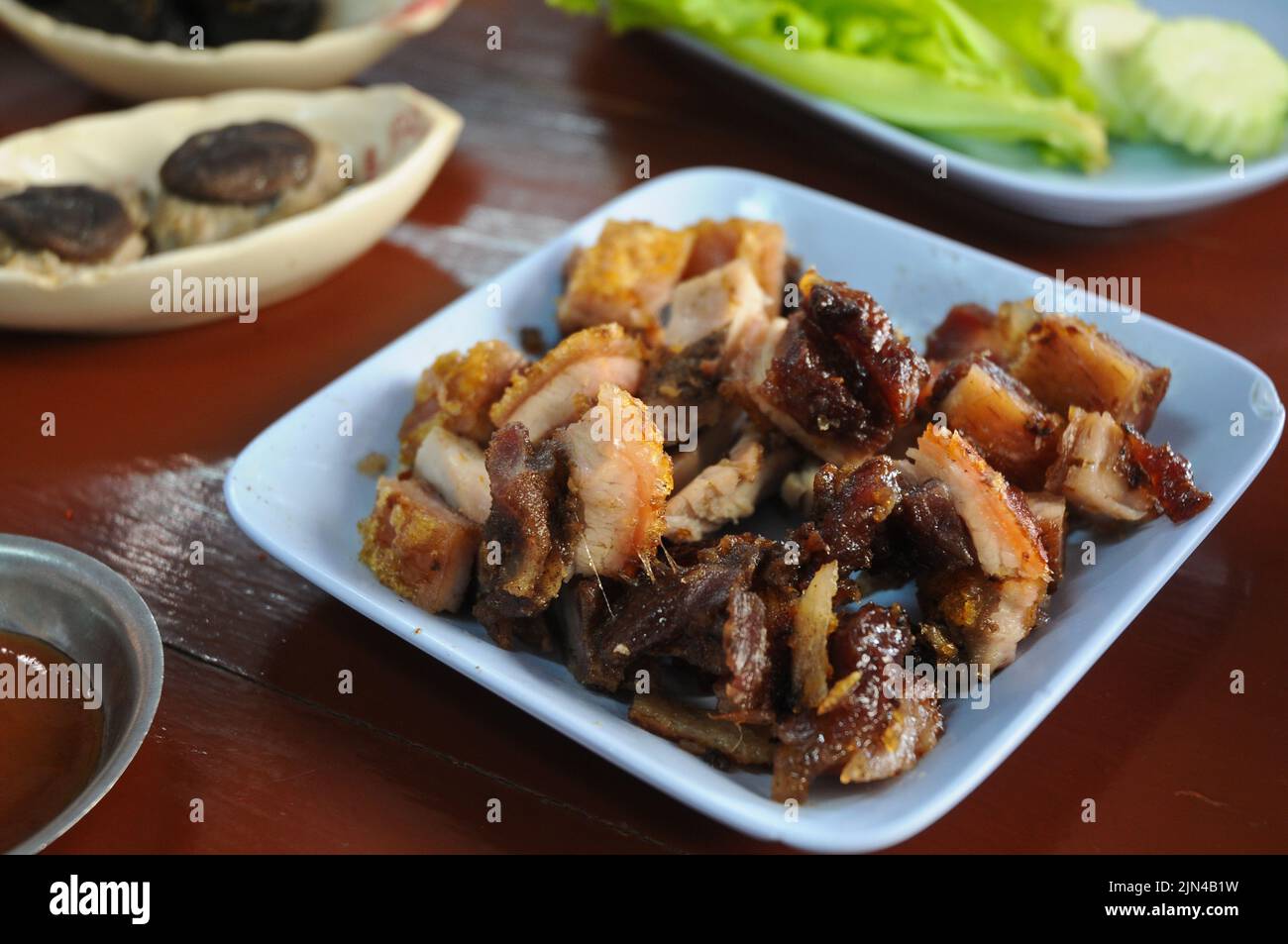 Thai style BBQ Roasted pork in blue dish for lunch Stock Photo