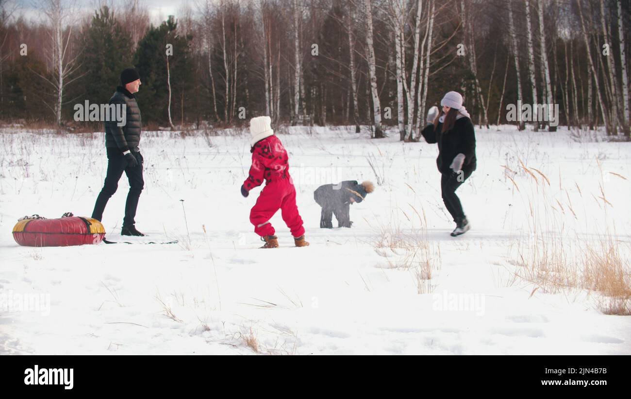 Family with two kids playing snowballs outdoors Stock Photo - Alamy