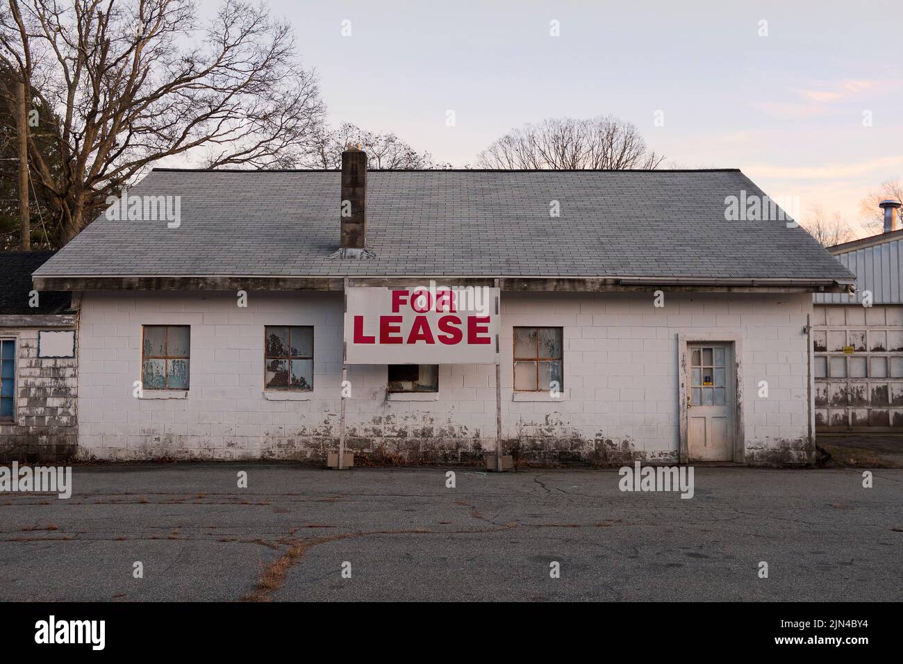 Dilapidated Cinder Block Building with For Lease Sign Stock Photo