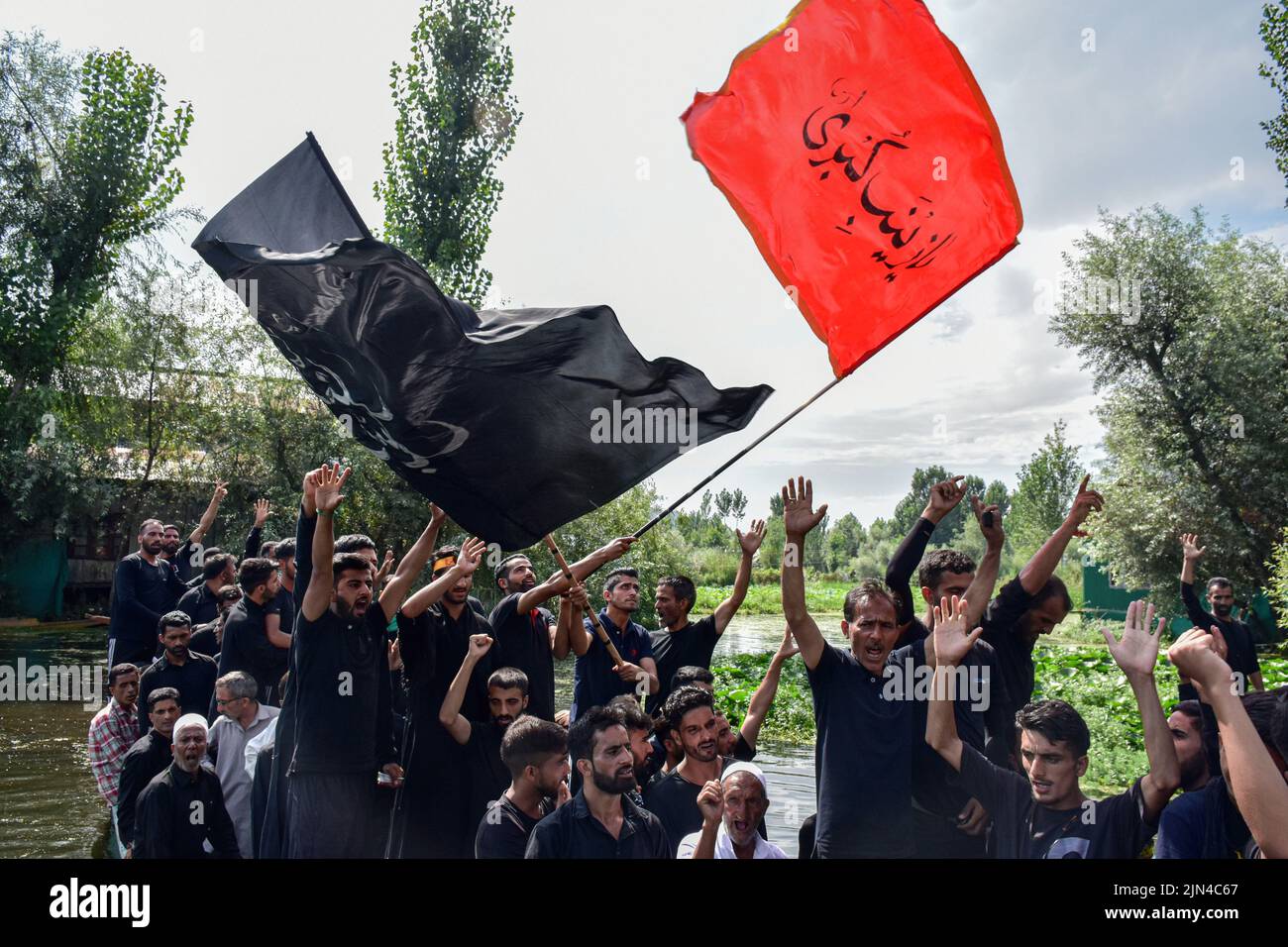 Kashmiri Shiite Muslims shout religious slogans as they ride on boats ...