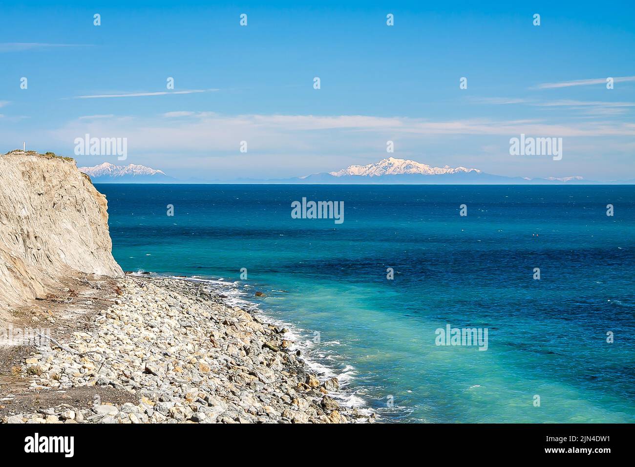 Snow covered Southern Alps as seen  from the Ngawi coast on the North Island Stock Photo
