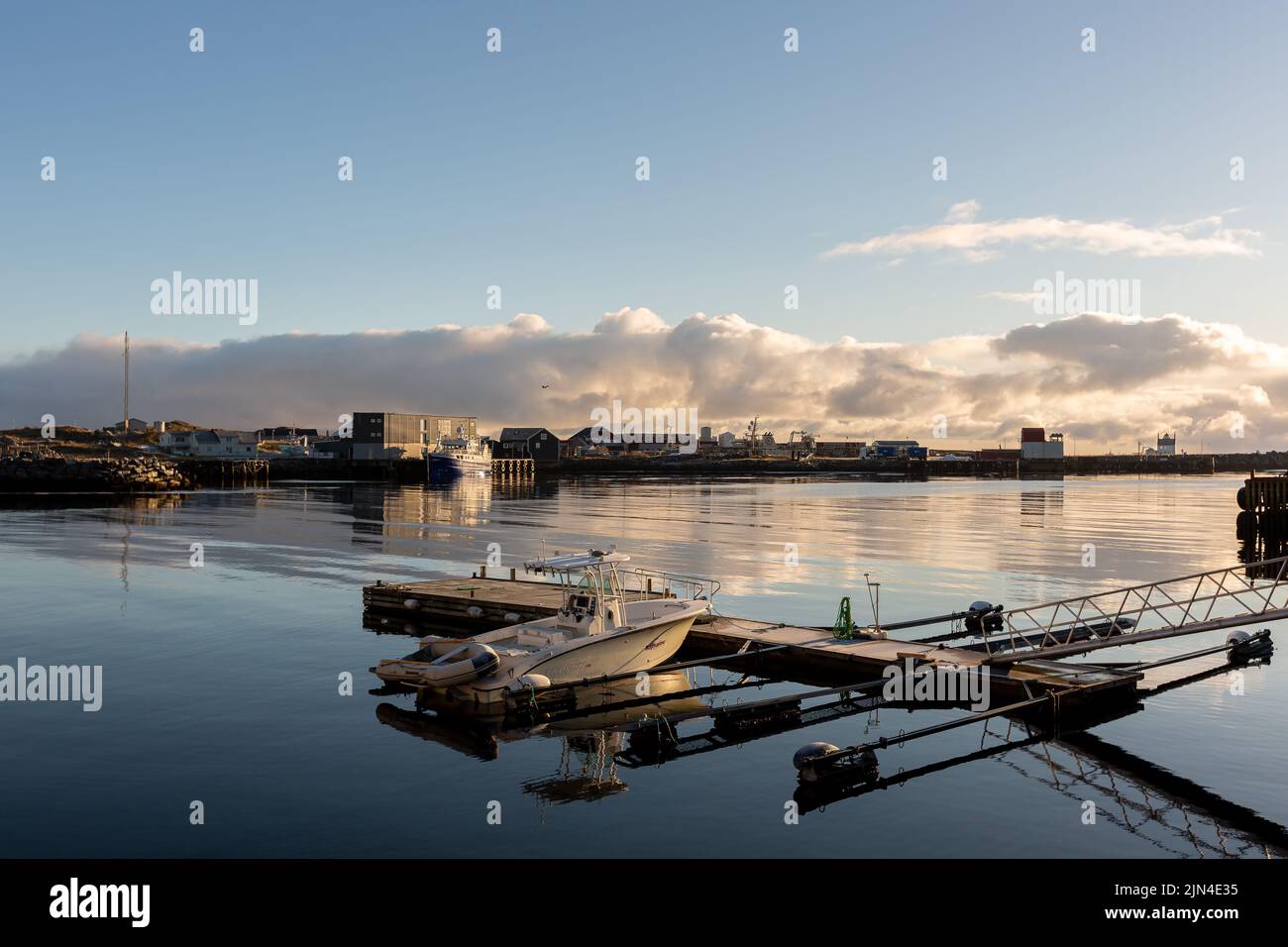 The view of a docked boat under the blue sky with the clouds reflecting ...