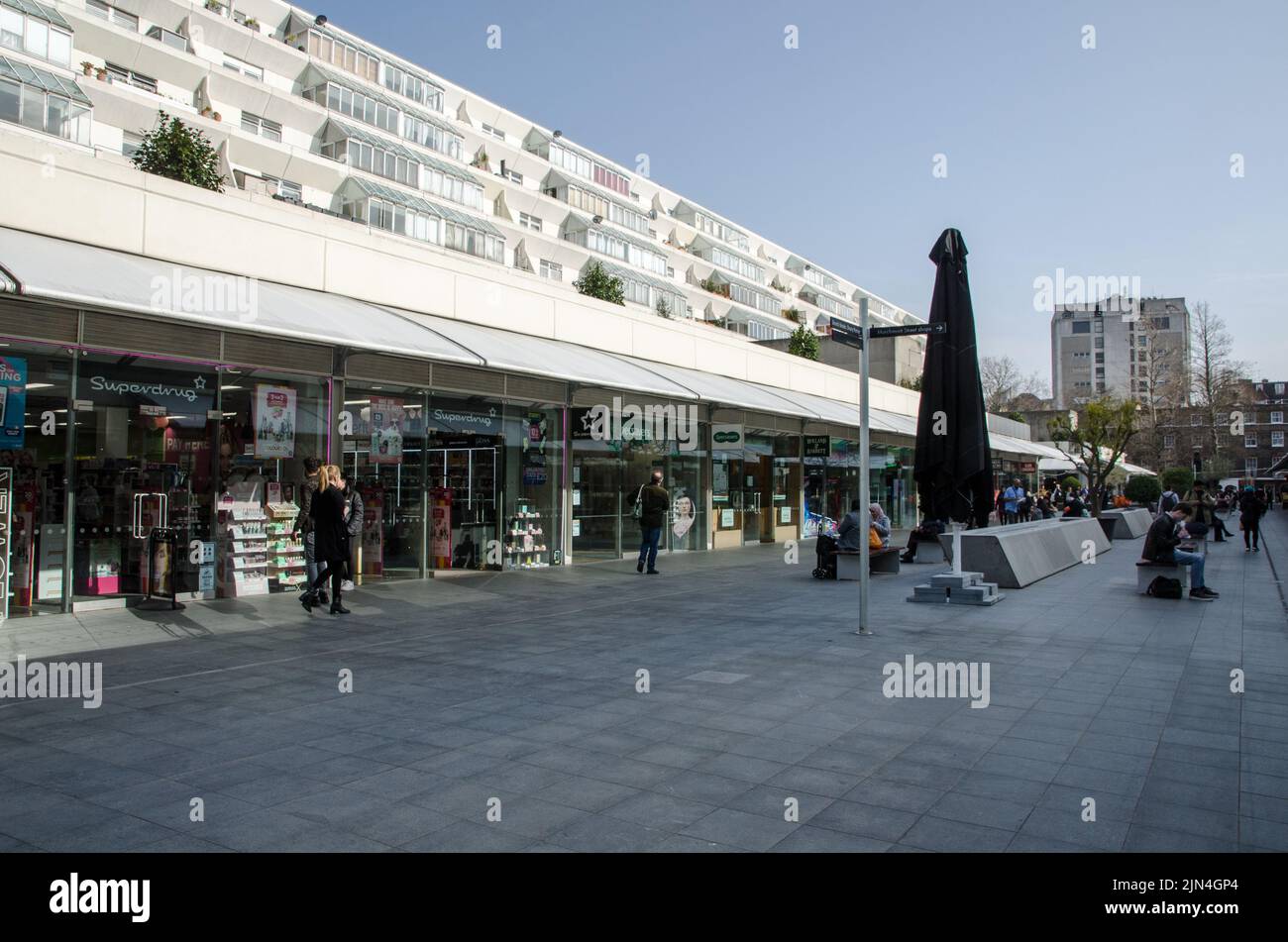 London, UK - March 21, 2022: Shoppers strolling along the Brunswick Shopping Centre in Bloomsbury, Central London.  Designed in a brutalist style by t Stock Photo