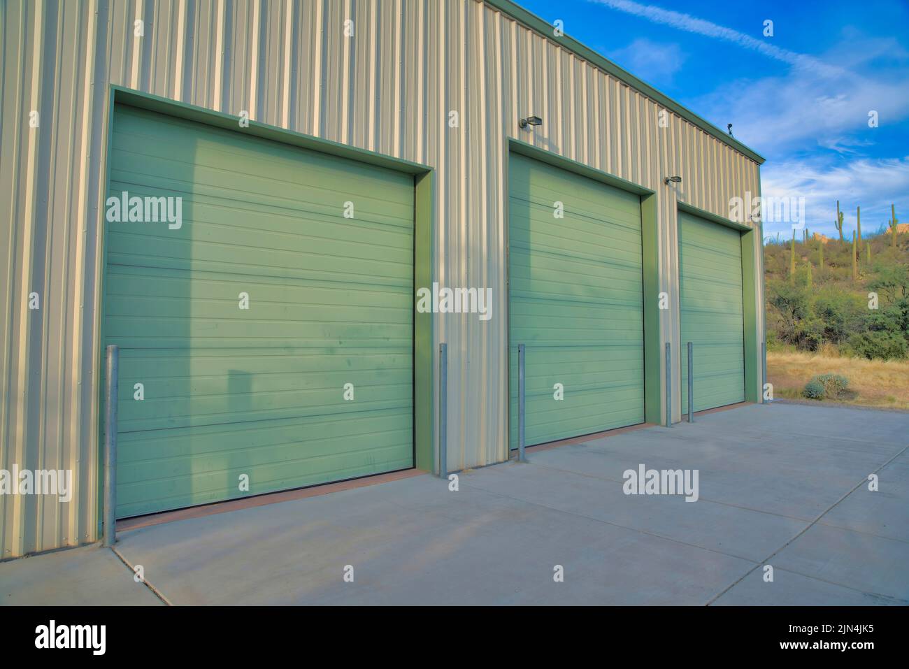 Three green garage doors with concerete driveway in Tucson, Arizona