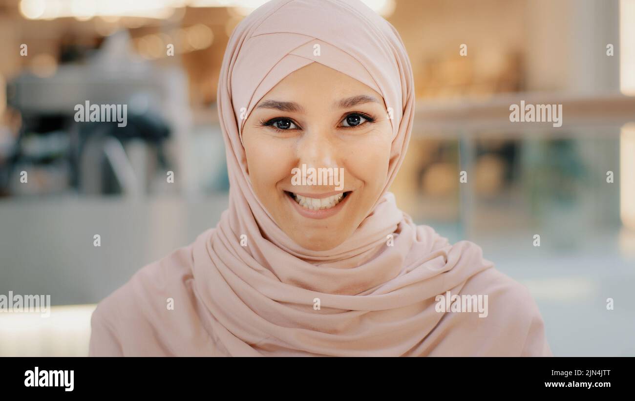 Webcam view young arab muslim woman in hijab speaks looking at camera smiling girl talking on cam job interview female entrepreneur explaining terms Stock Photo