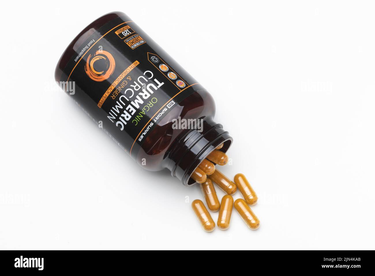 An open bottle of turmeric capsules Stock Photo