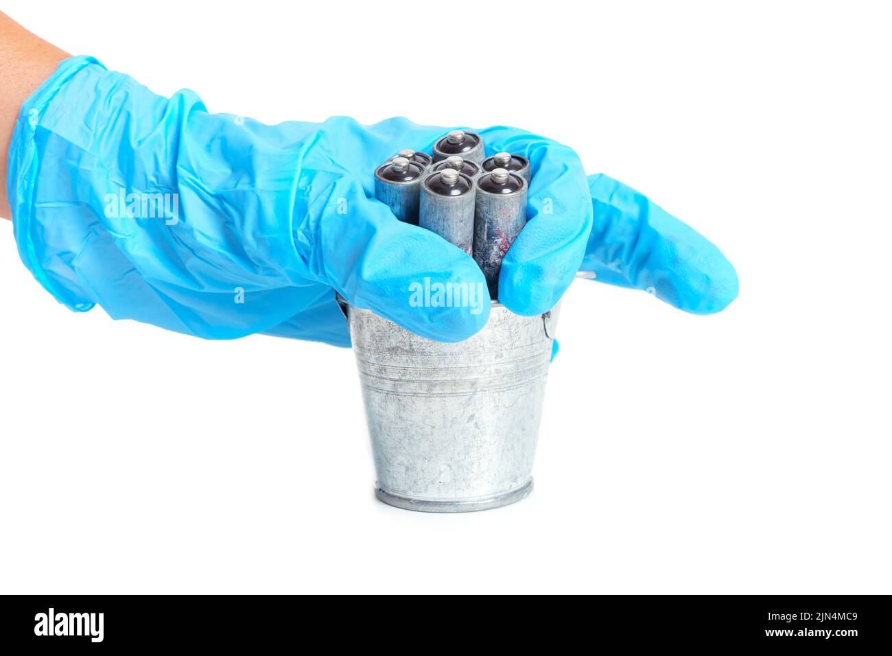 Throwing dead corroded batteries in a small steel bucket isolated on