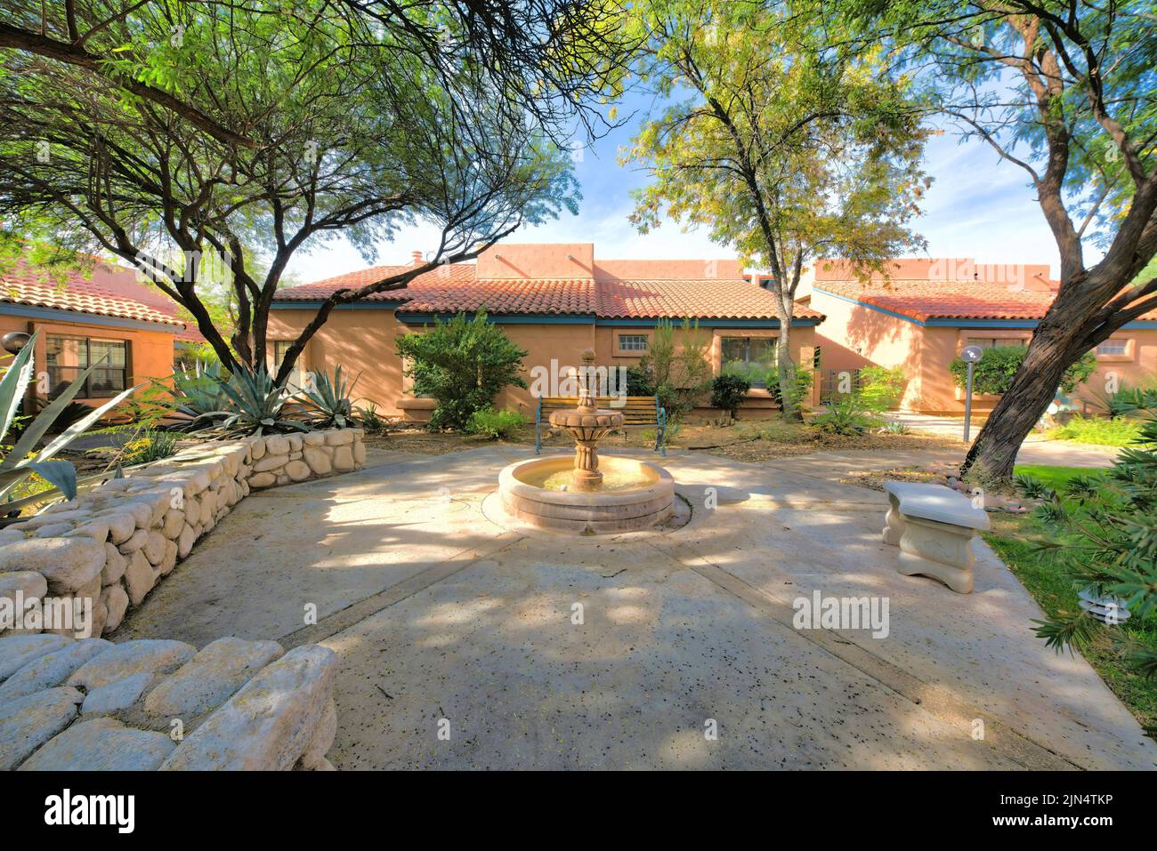 Italianate houses surrounding the small outdoor lounge area in Tucson, Arizona. There is a water