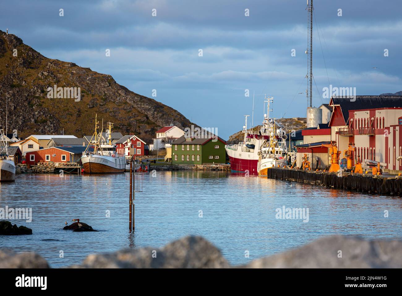 The view of colorful buildings and boats by the lake under the blue cloudy sky in the Lofoten village Stock Photo