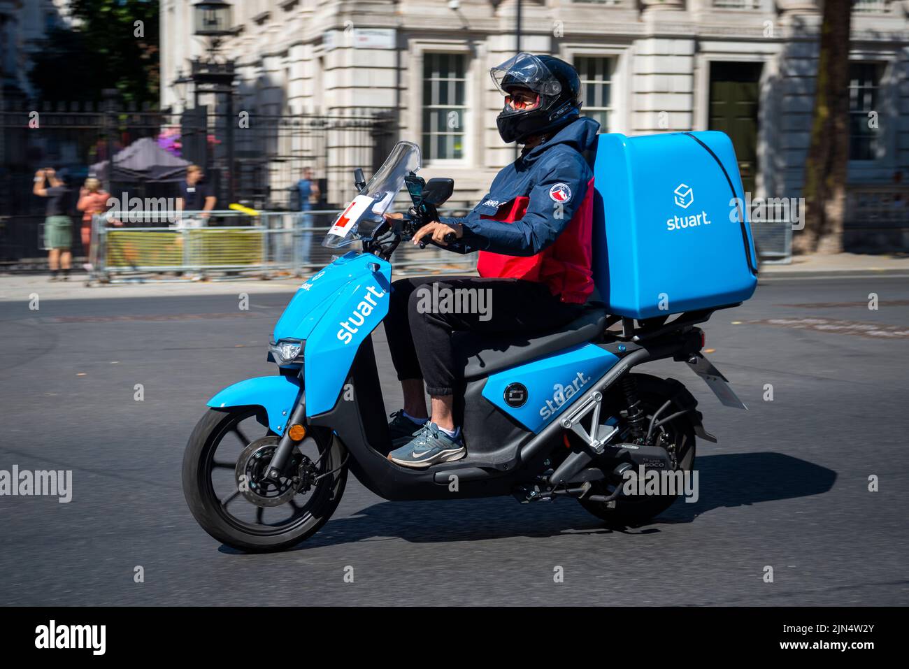 stuart courier delivery motorbike on Whitehall, Westminster, London, UK. An on-demand logistics business. Super Soco electric motorcycle. Vmoto soco Stock Photo