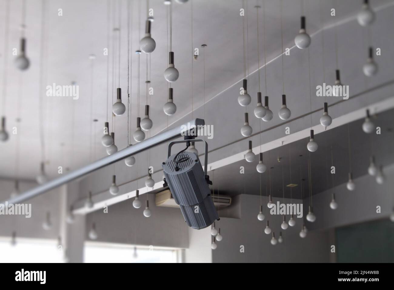 Tracking spotlight on the ceiling rail system and round ceiling lamps Stock Photo