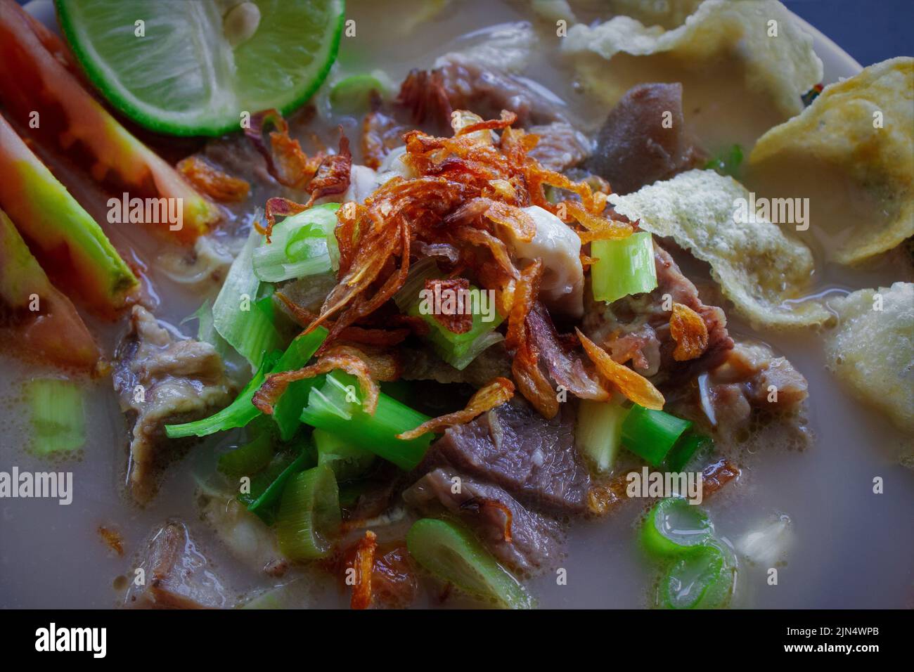 sop kaki kambing a traditional food from Betawi, Jakarta Indonesia, made from mutton or lamb, offal, spices. isolated on black background.This food is Stock Photo