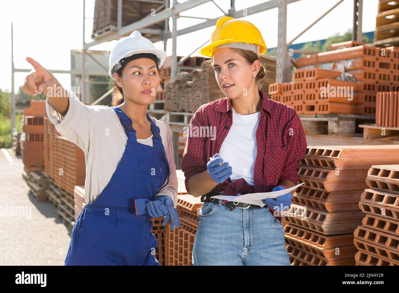 Female workers having conversation in outdoot warehouse Stock Photo