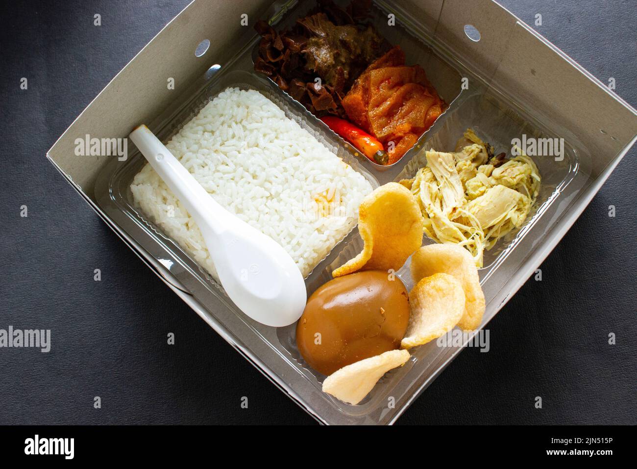 lunch boxes gudeg are similar to Bento boxes - rice boxes, rice, catering boxes, food services (rice warm, sweet eggs, krecek, tofu, tempeh, pieces of Stock Photo