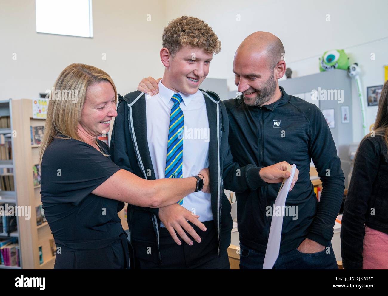 Student Reuben Banks celebrates his exam results with his parents at