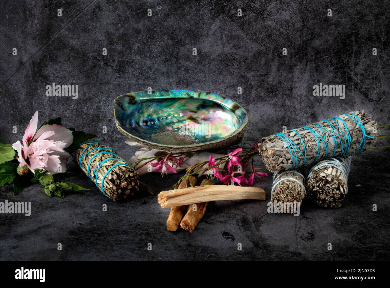 sage, palo santo and abalone in front of gray background Stock Photo