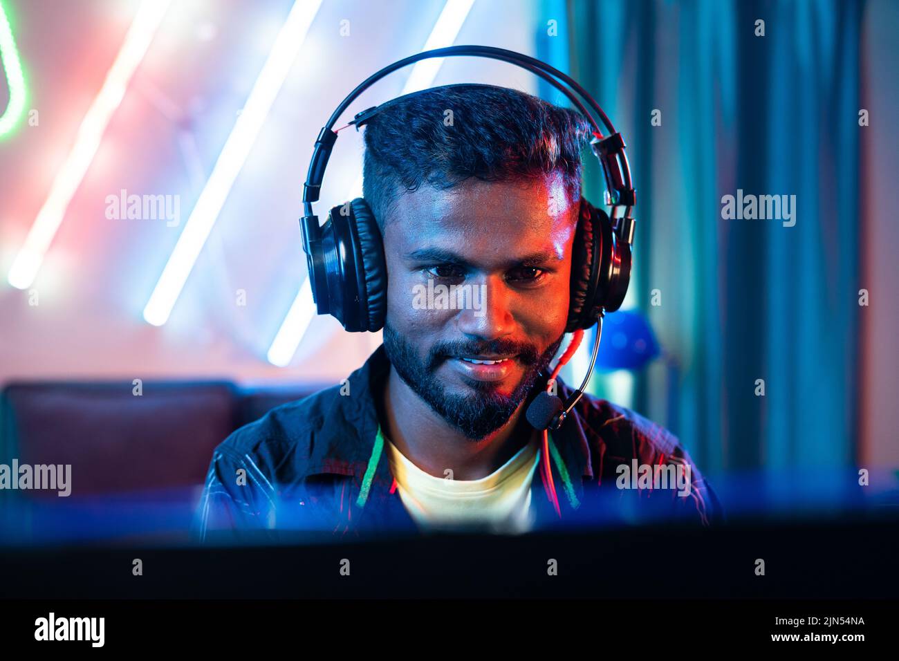 close up head shot of professional gamer talking on headphone while