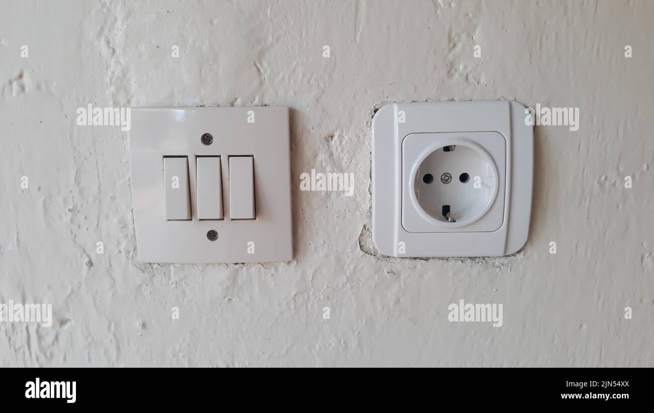 Switch and Electric socket and white wall Switch and Electric socket and white wall Stock Photo