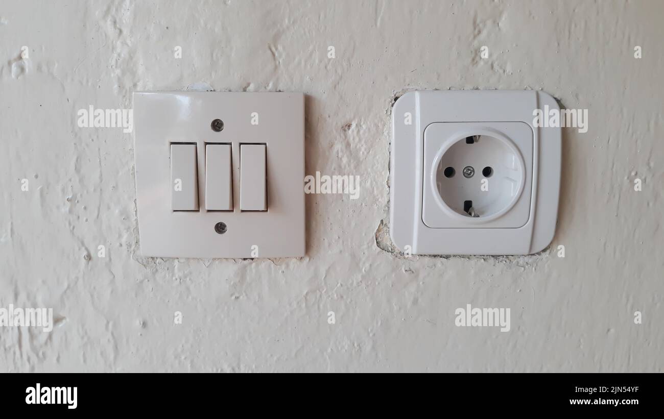 Switch and Electric socket and white wall Switch and Electric socket and white wall Stock Photo