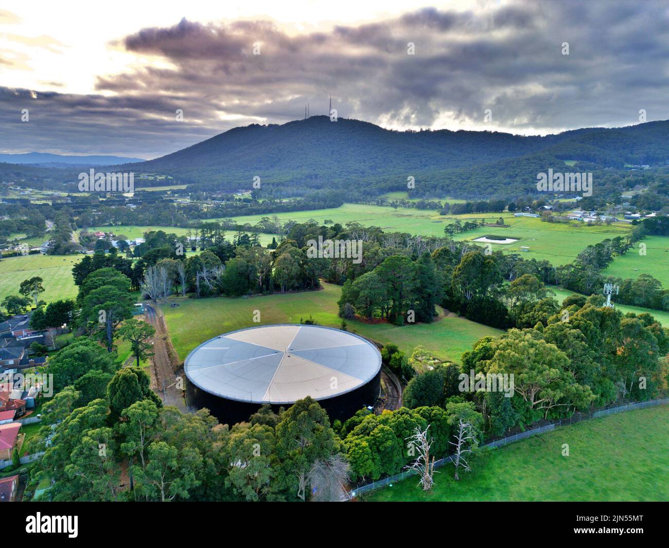 Aerial shot of a green field and Mount Dandenong in Victoria Australia Stock Photo