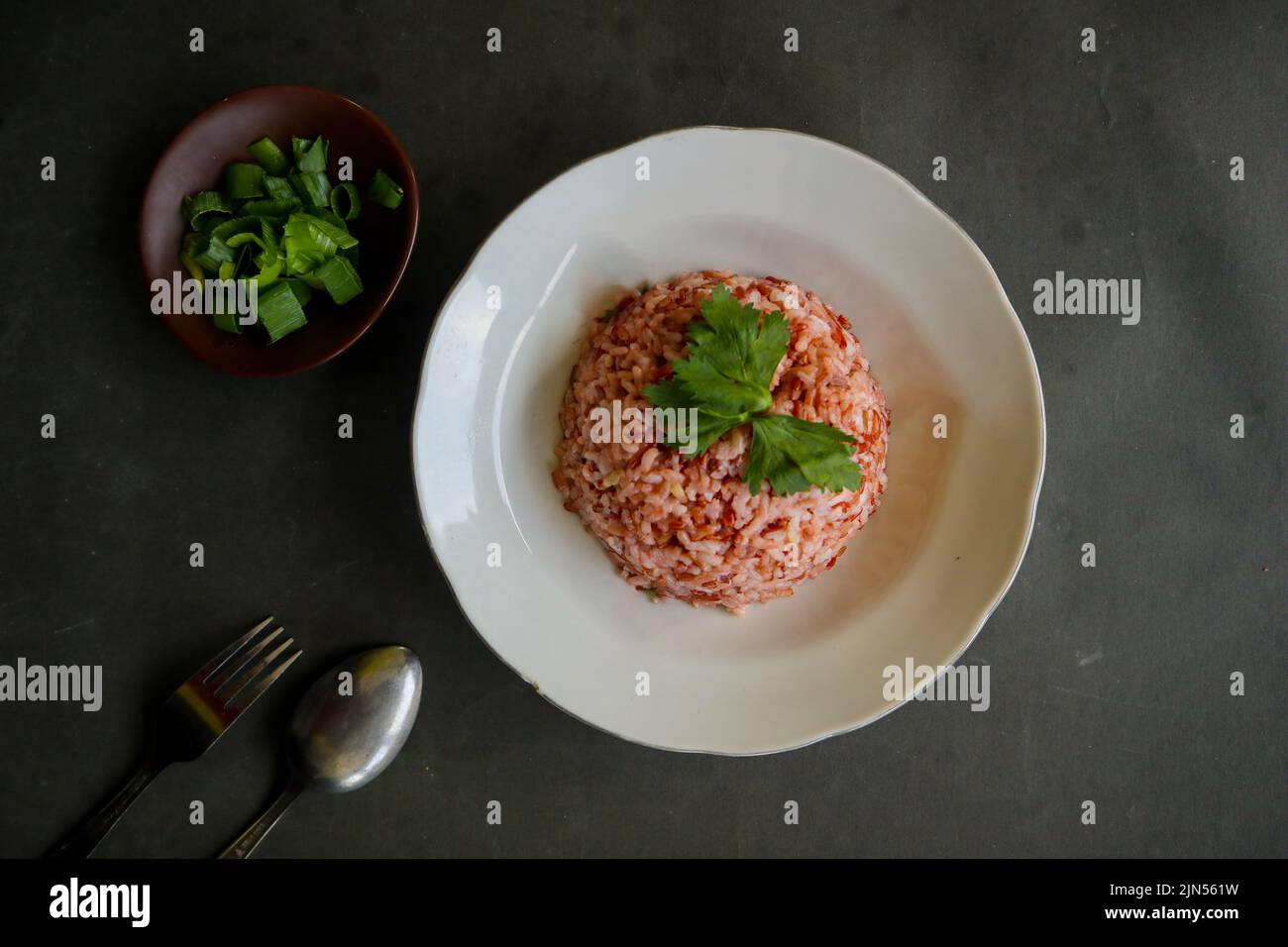 Red steamed rice or nasi merah served in plate isolated on black ...