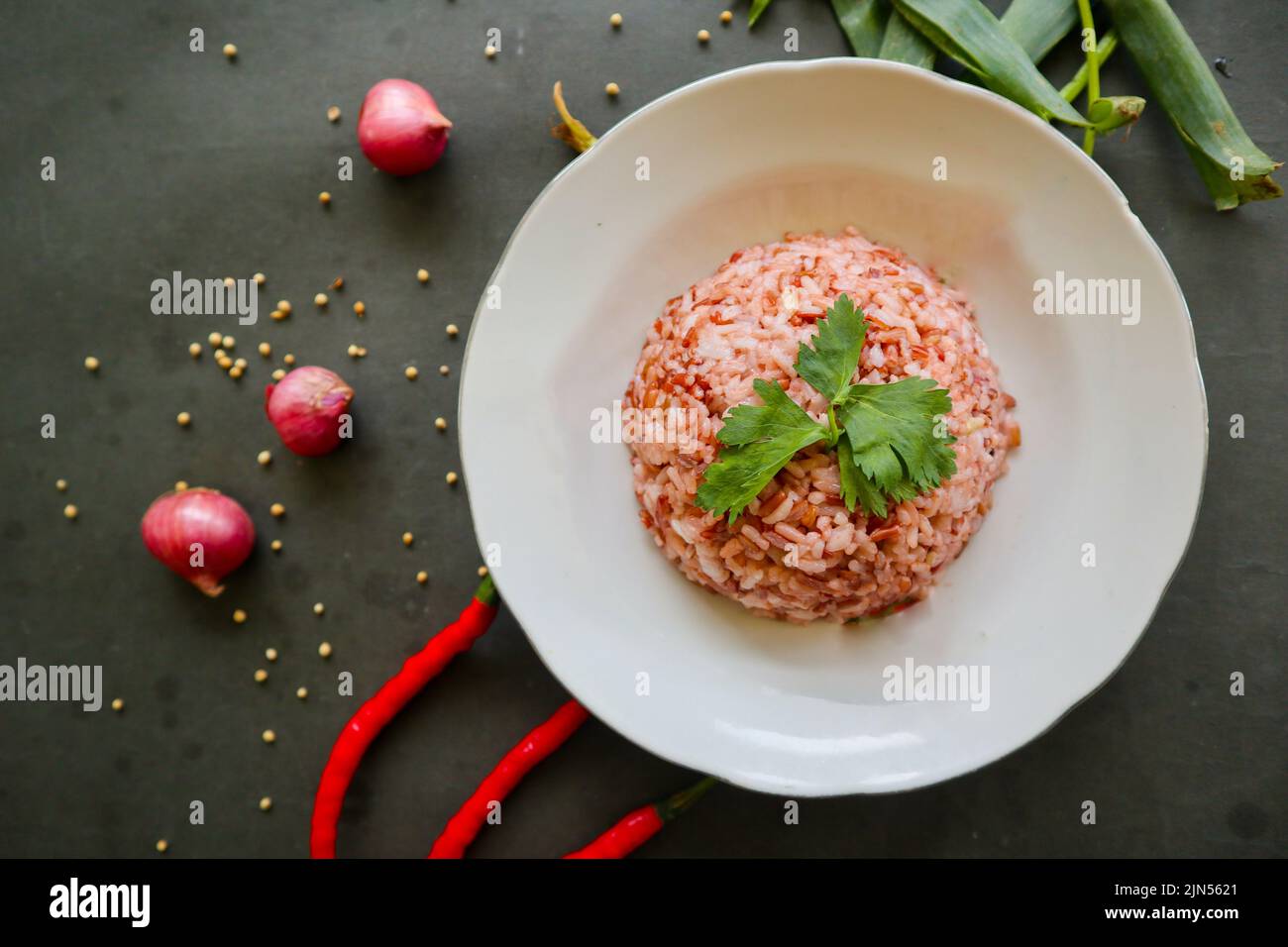 Red steamed rice or nasi merah served in plate isolated on black ...