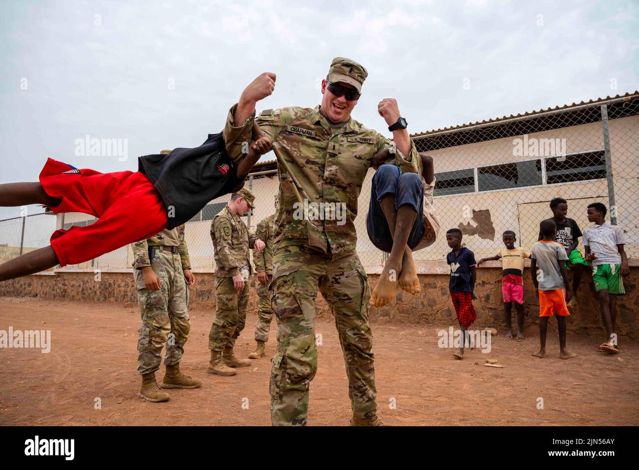 Chabelley Village, Djibouti. 15th July, 2022. U.S. Army 1st Lt. Austin Chapman, 268th Military Police Company command executive, lifts two children up during a visit at Chabelley village, Djibouti, July 15, 2022. U.S. Combined Joint Task Force-Horn of Africa and 449th Air Expeditionary Group personnel, located at Camp Lemonnier, Djibouti, regularly work with government leaders and citizens on a variety of projects to promote stability in East Africa. Credit: U.S. Air Force/ZUMA Press Wire Service/ZUMAPRESS.com/Alamy Live News Stock Photo