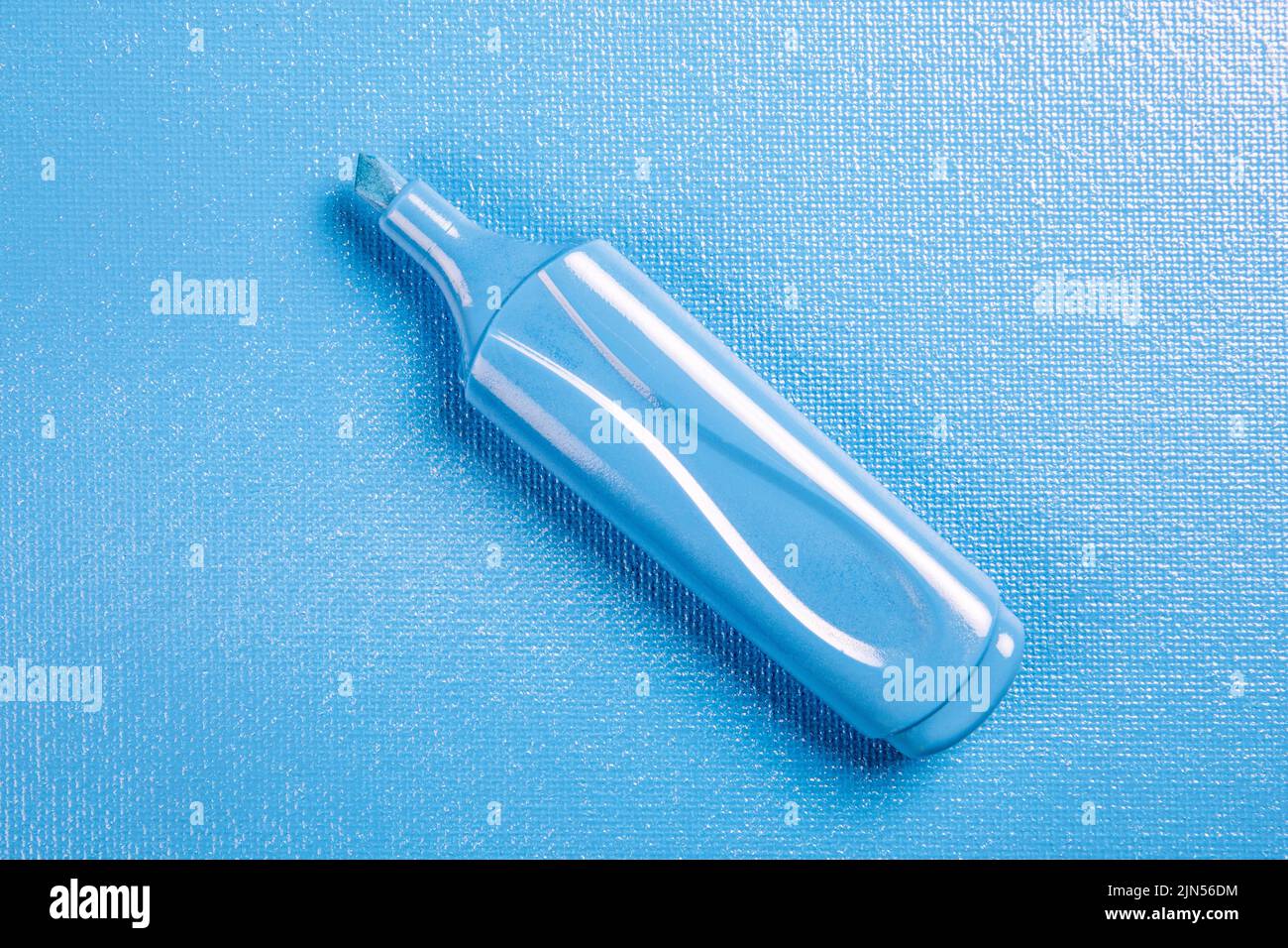 Blue marker on a blue textured background. Stock Photo