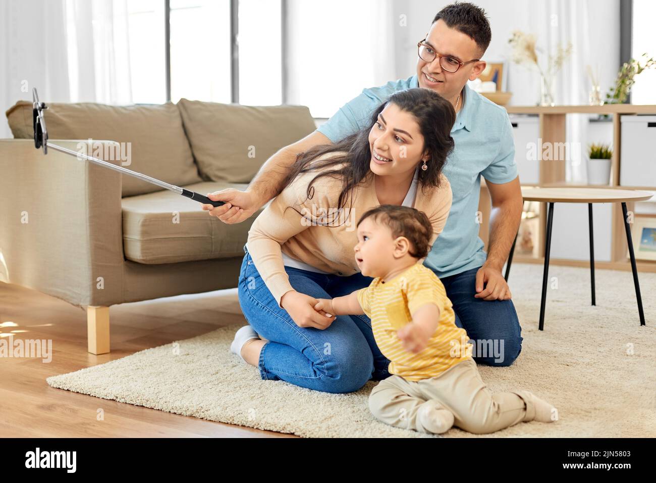 happy family with child sitting on sofa at home Stock Photo