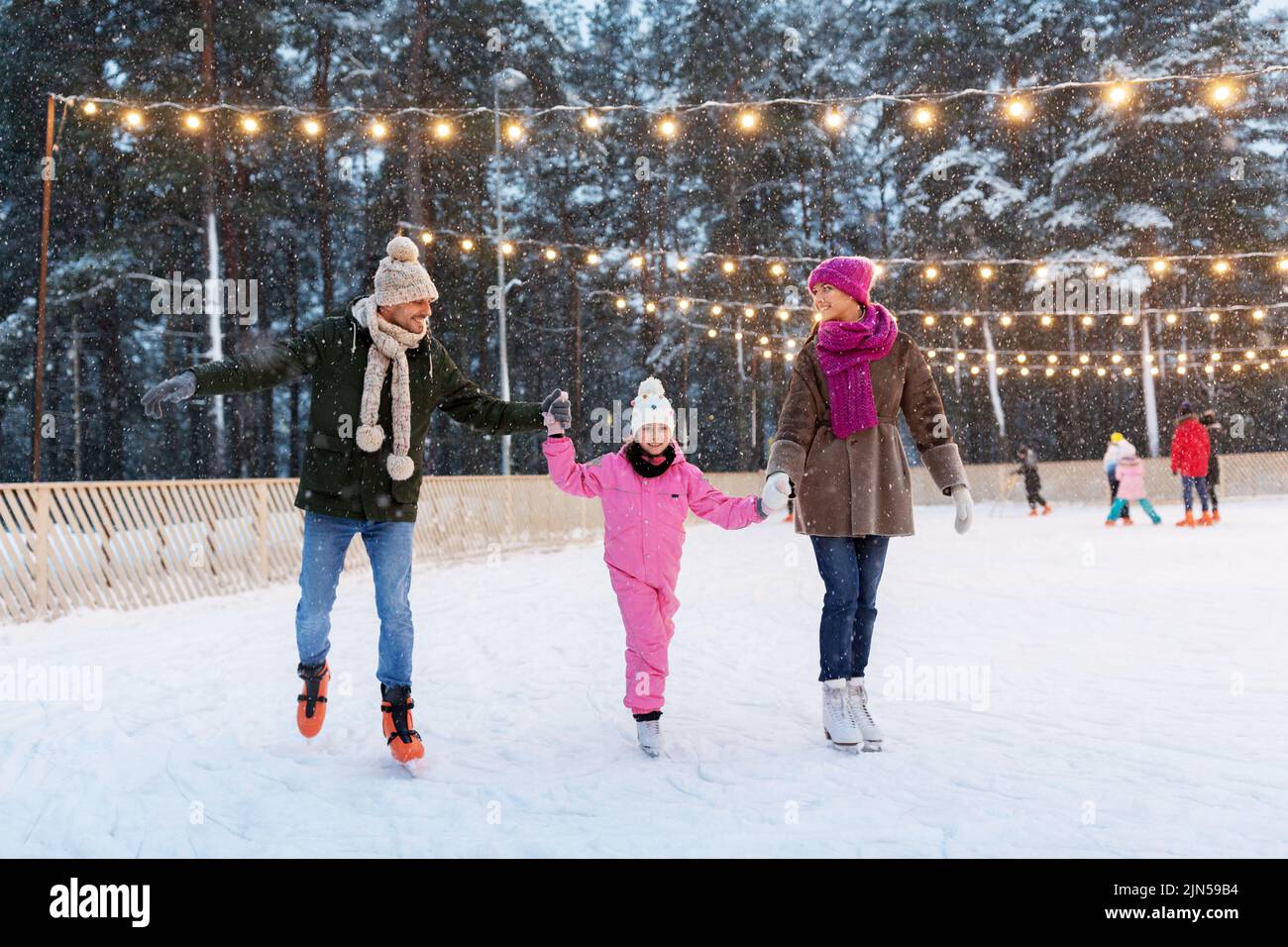 happy family at outdoor skating rink in winter Stock Photo