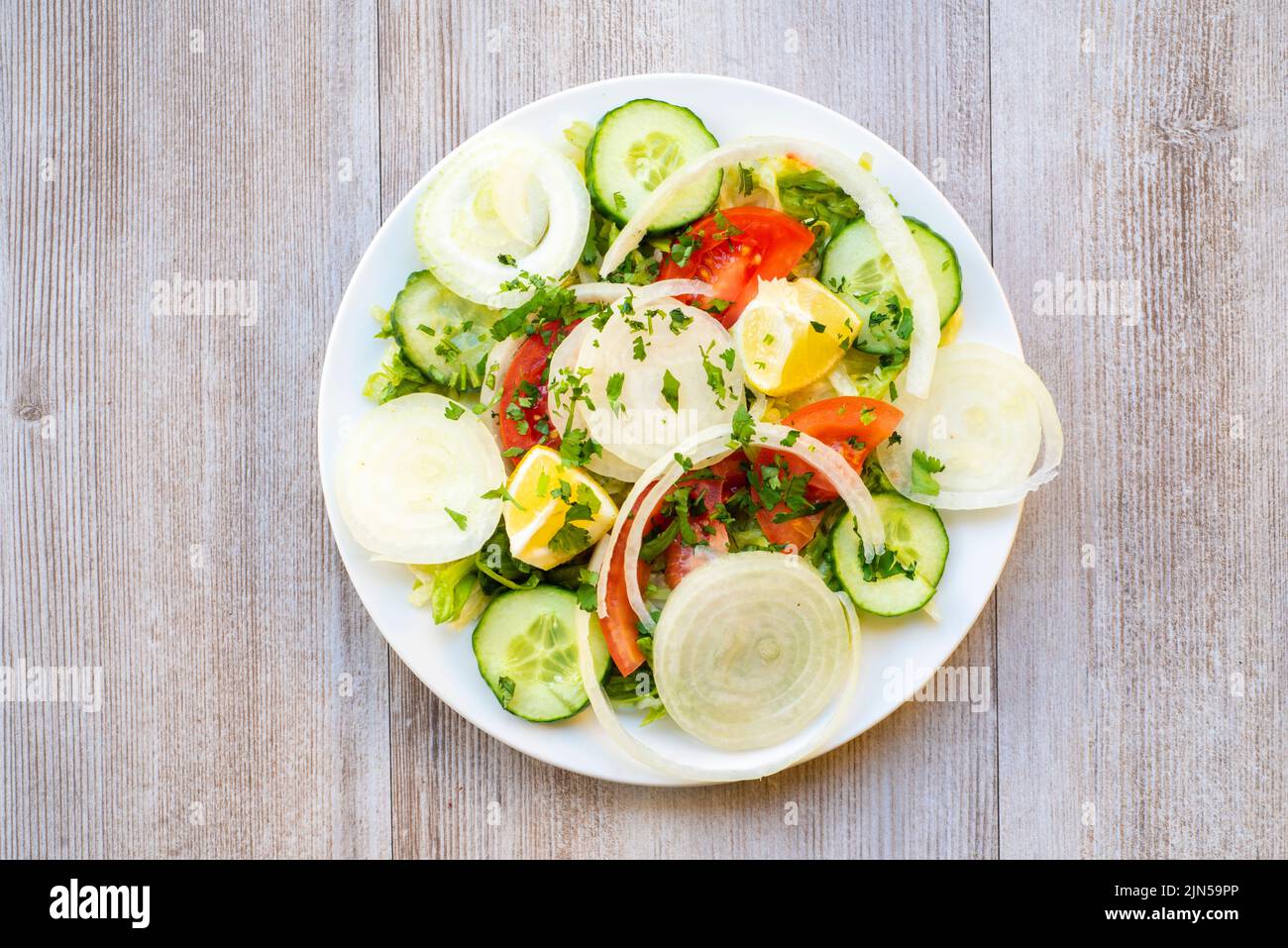 Doncaster, UK - 2019 Mar 21: Green Salad with lettuce, cucumber, onion and tomato from Goa Indian Stock Photo