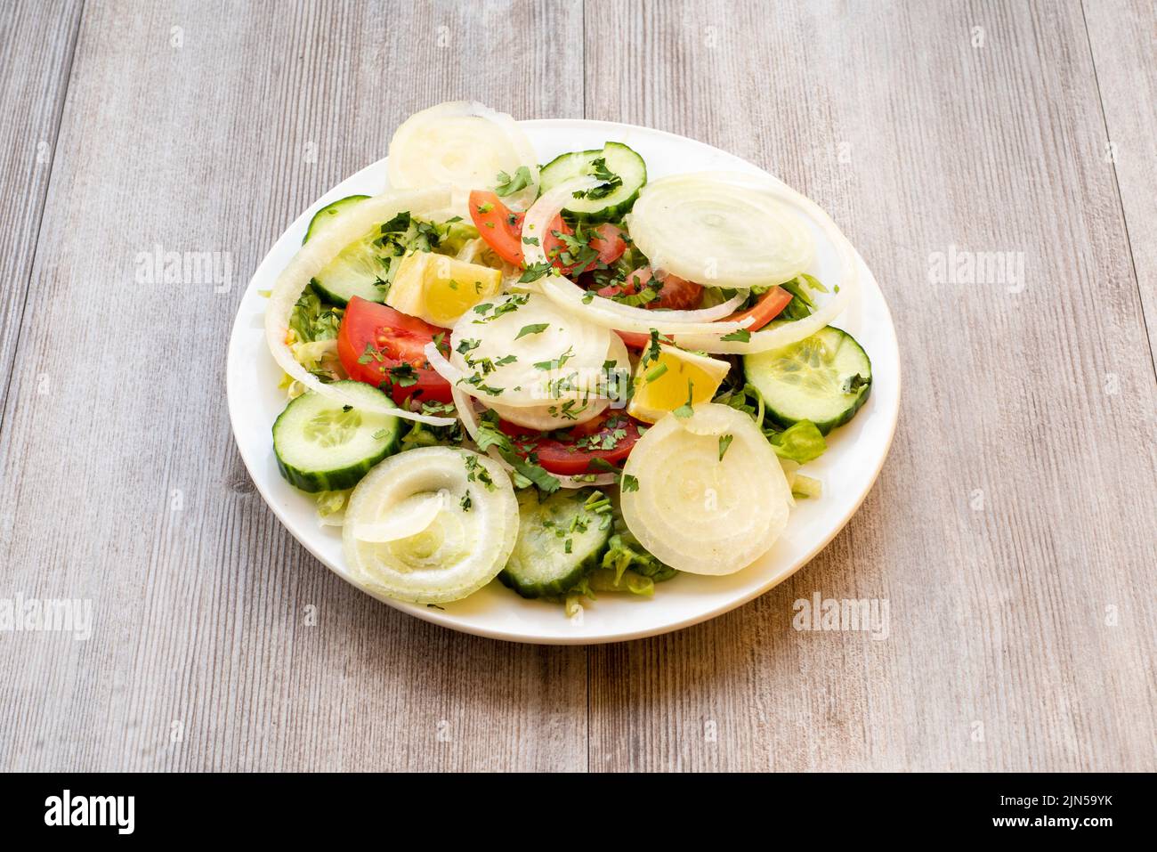 Doncaster, UK - 2019 Mar 21: Green Salad with lettuce, cucumber, onion and tomato from Goa Indian Stock Photo