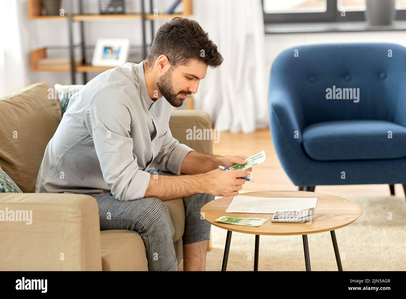 man with money and calculator filling papers Stock Photo