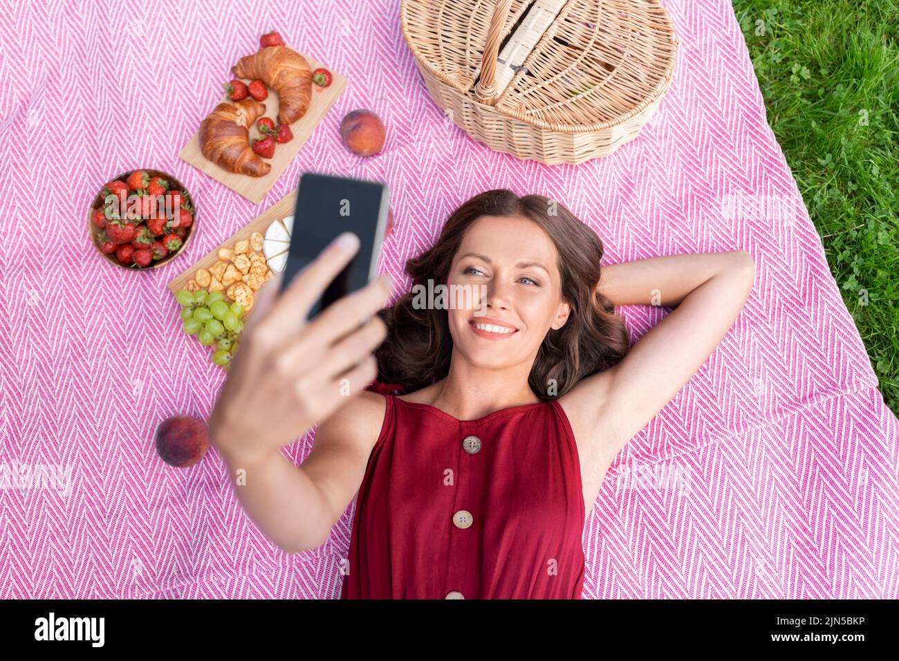 happy woman with smartphone taking selfie at park Stock Photo