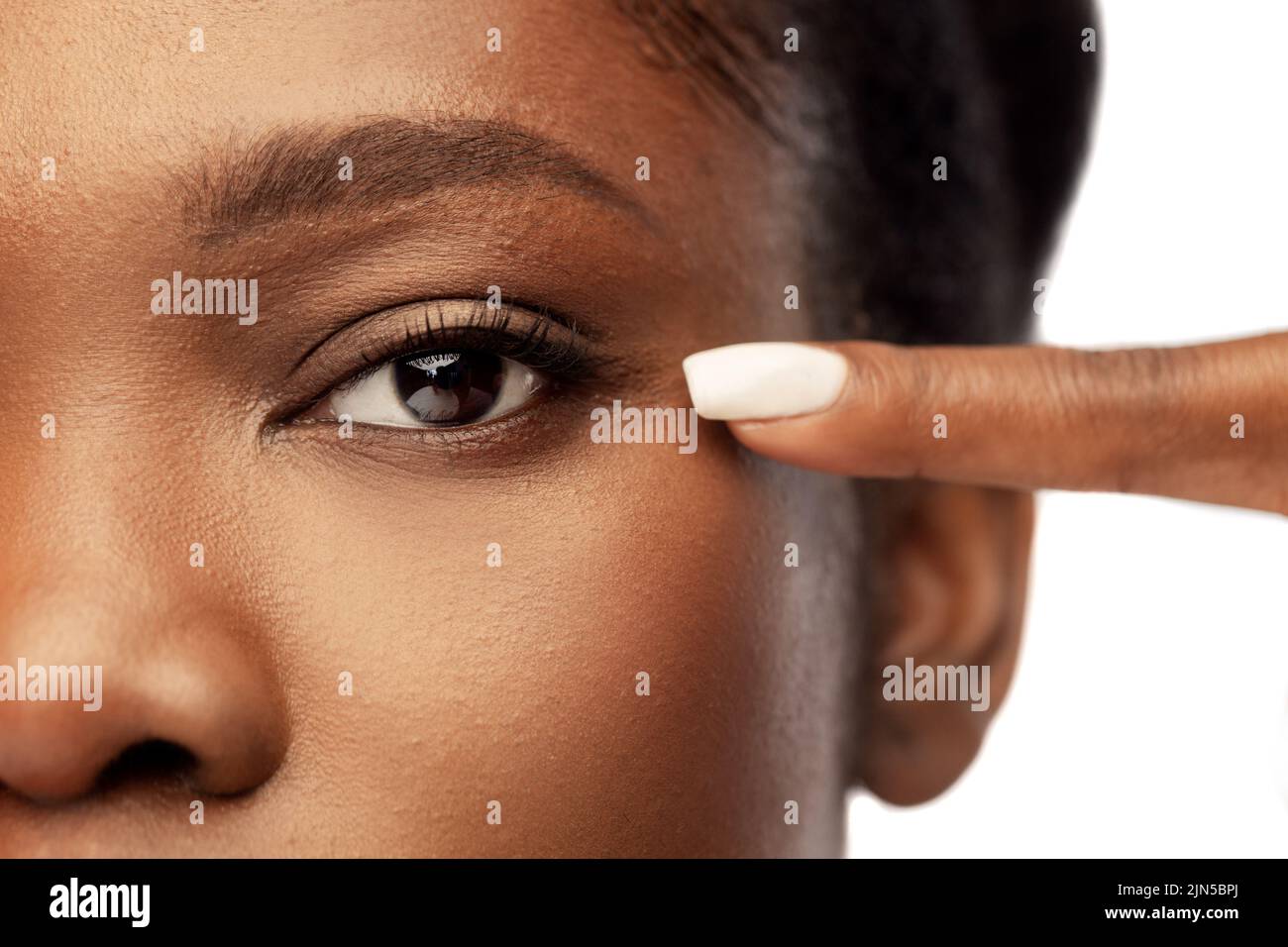 beautiful african woman pointing to her eye Stock Photo