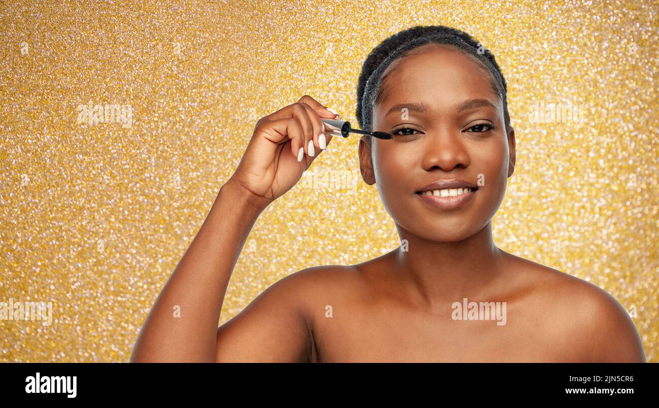 beautiful african american woman applying mascara Stock Photo