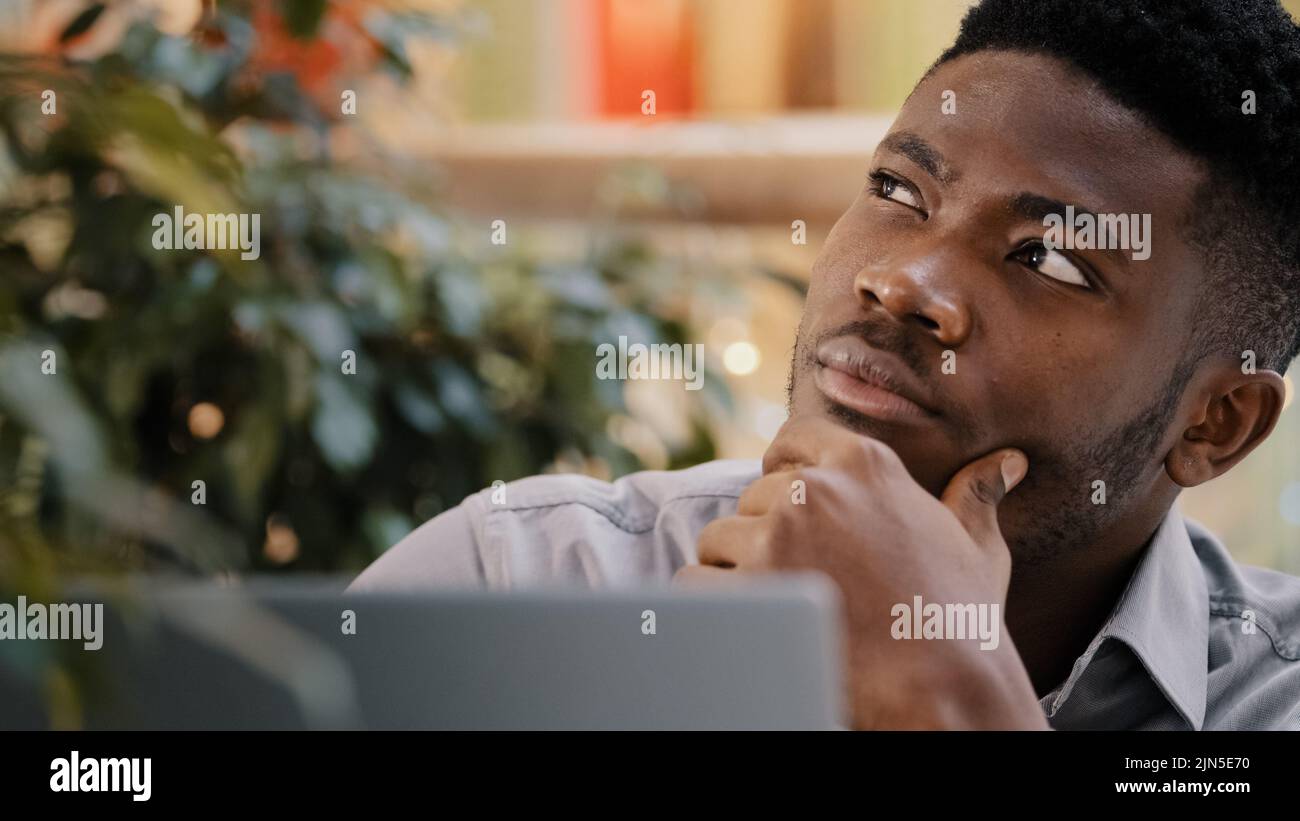 Close-up pensive confident manager freelancer working on laptop writes report thinks about solving problem startup new idea focused deep in thought Stock Photo