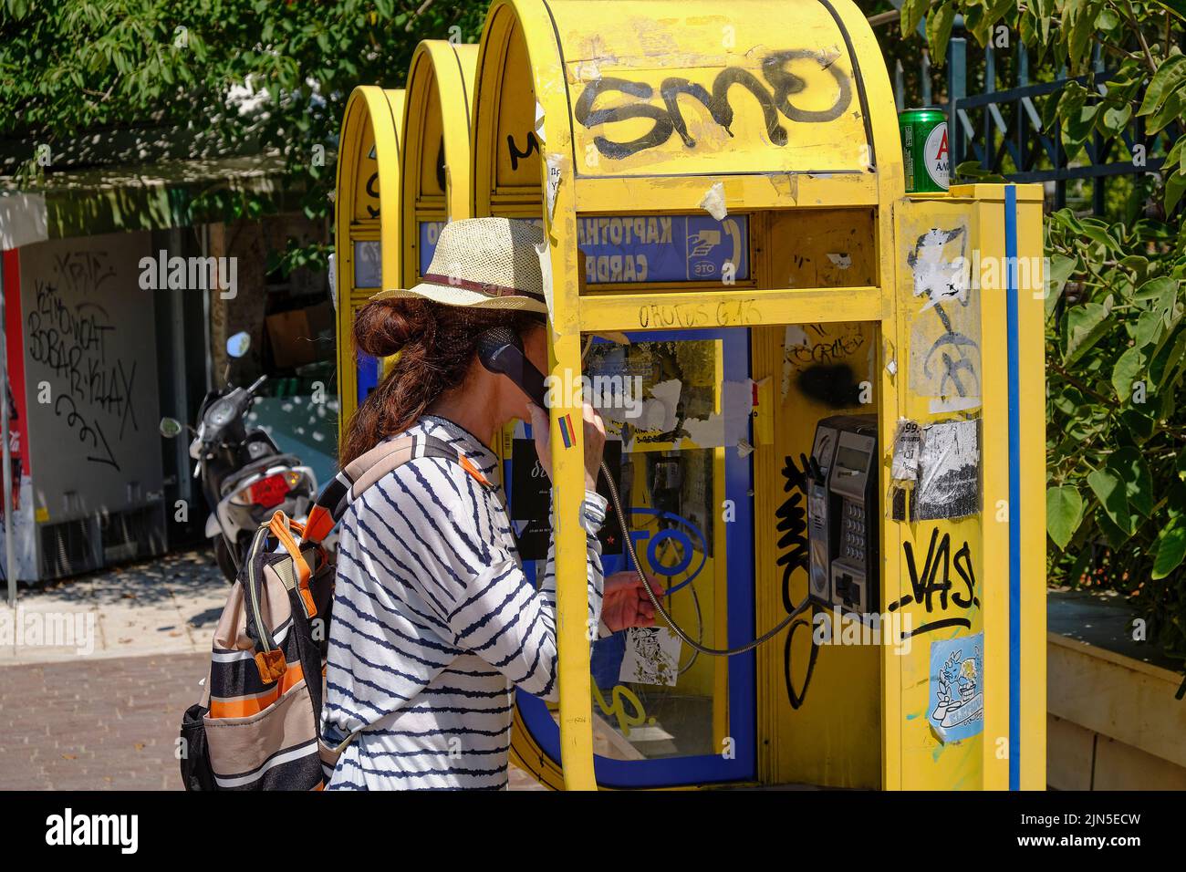 woman using a public telephone in central Athens Stock Photo