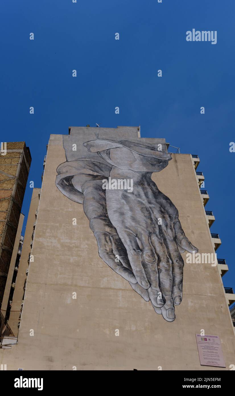 Giant mural of Praying Hands in central Athens by Pavlos Tsakonas and Manolis Anastasakos Stock Photo