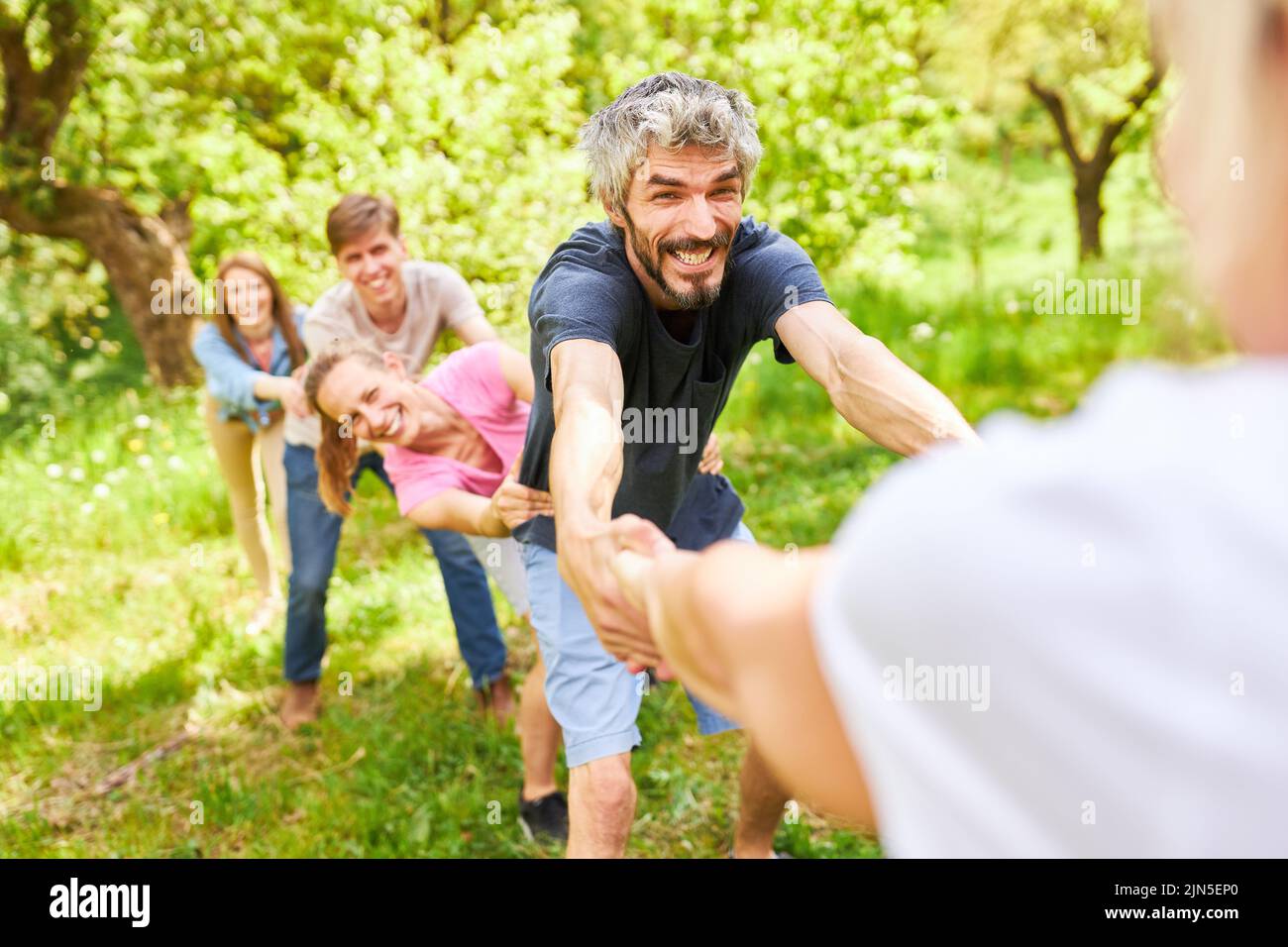 Ambitious young team measuring their strength against another team in nature Stock Photo