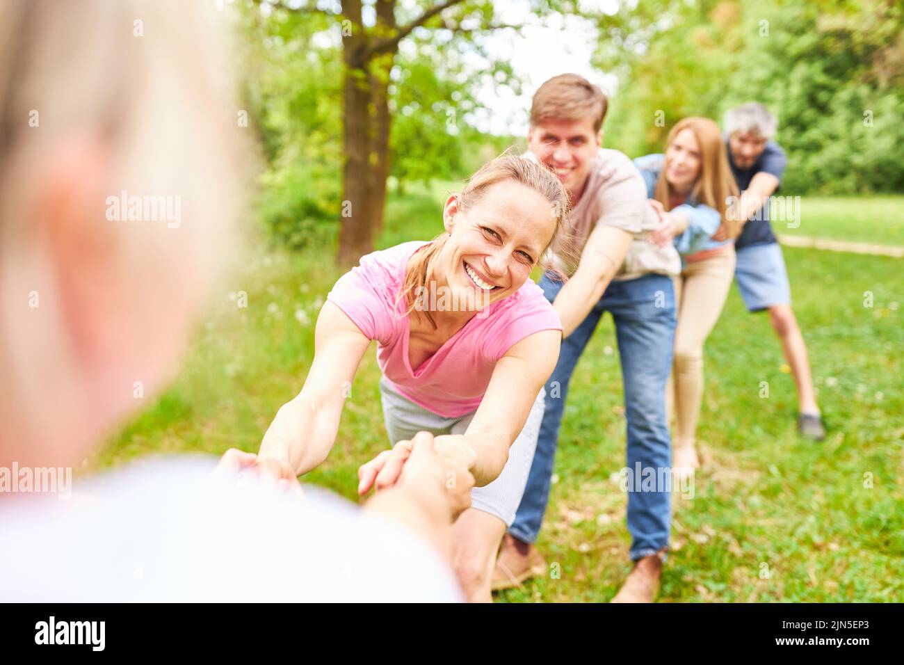 Young people in outdoor camp in two teams hold hands in competition Stock Photo