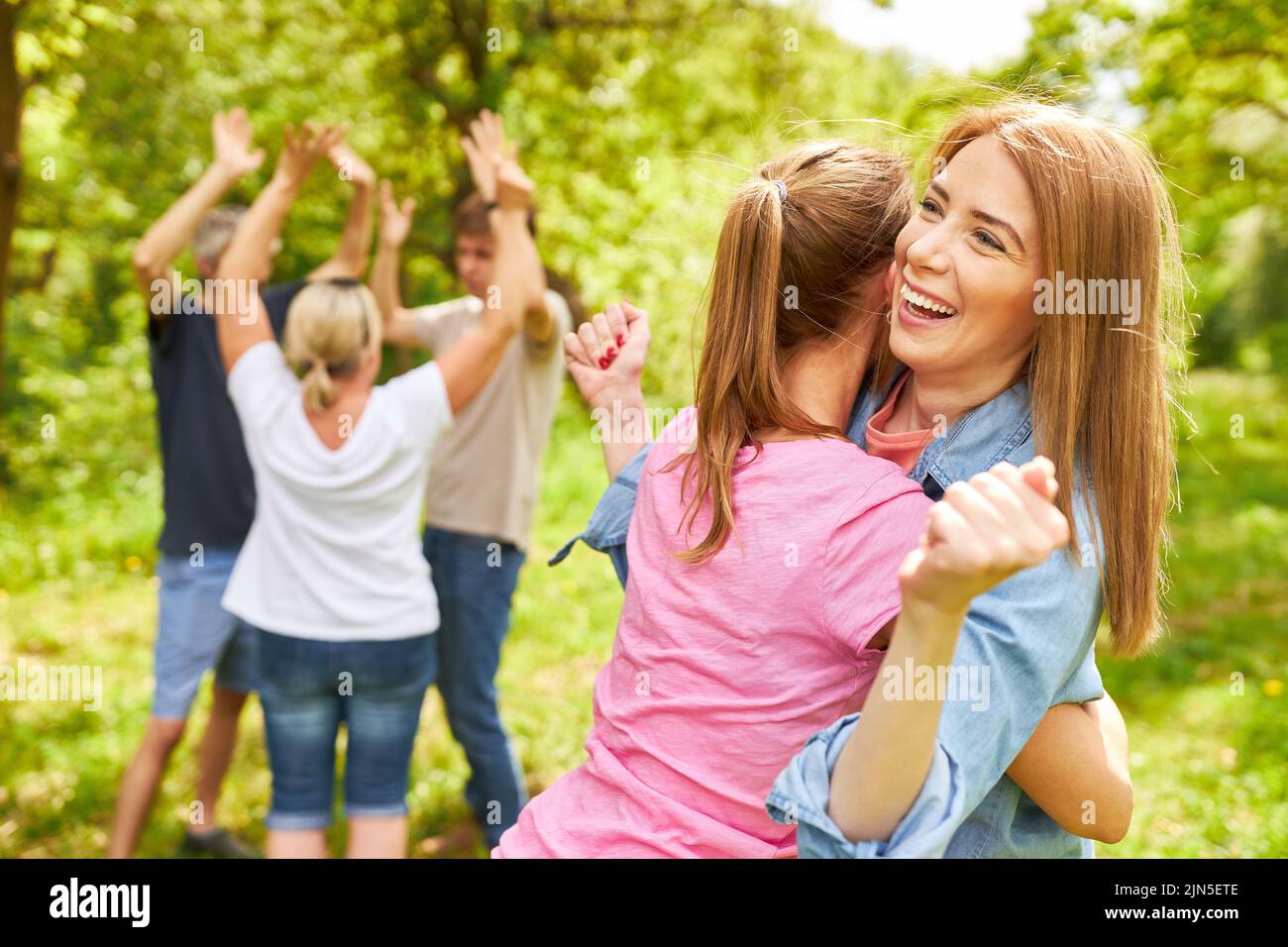 Young women and team colleagues hugging each other happily rejoicing in a success Stock Photo